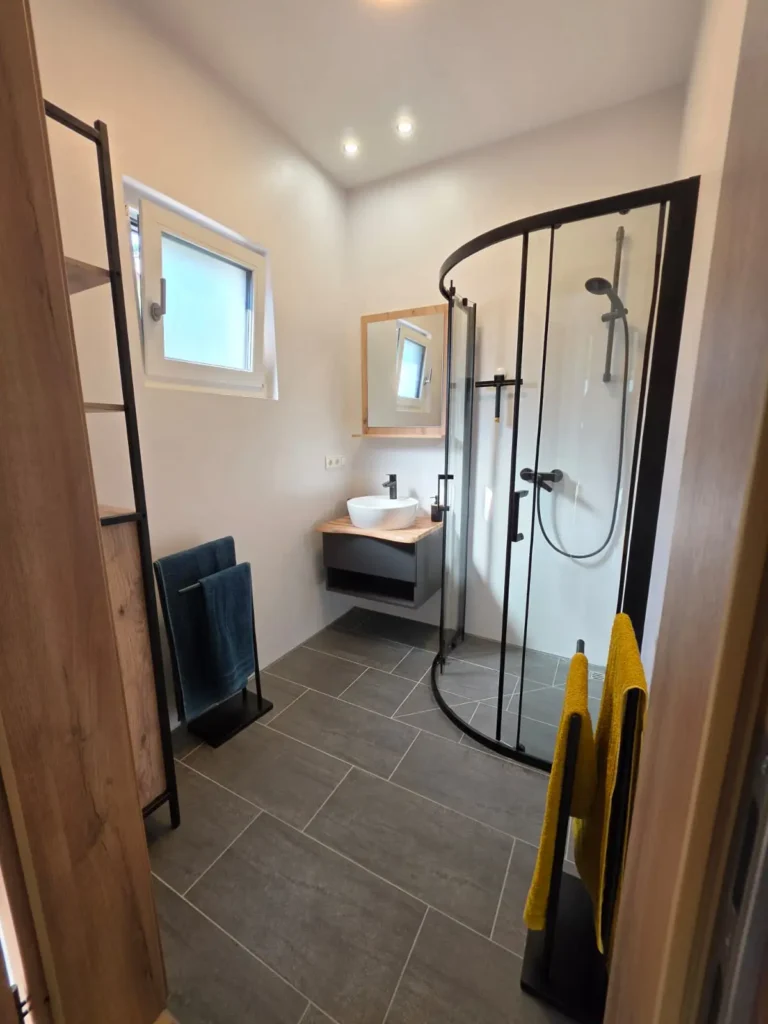 Badezimmer mit Dusche und Waschbecken