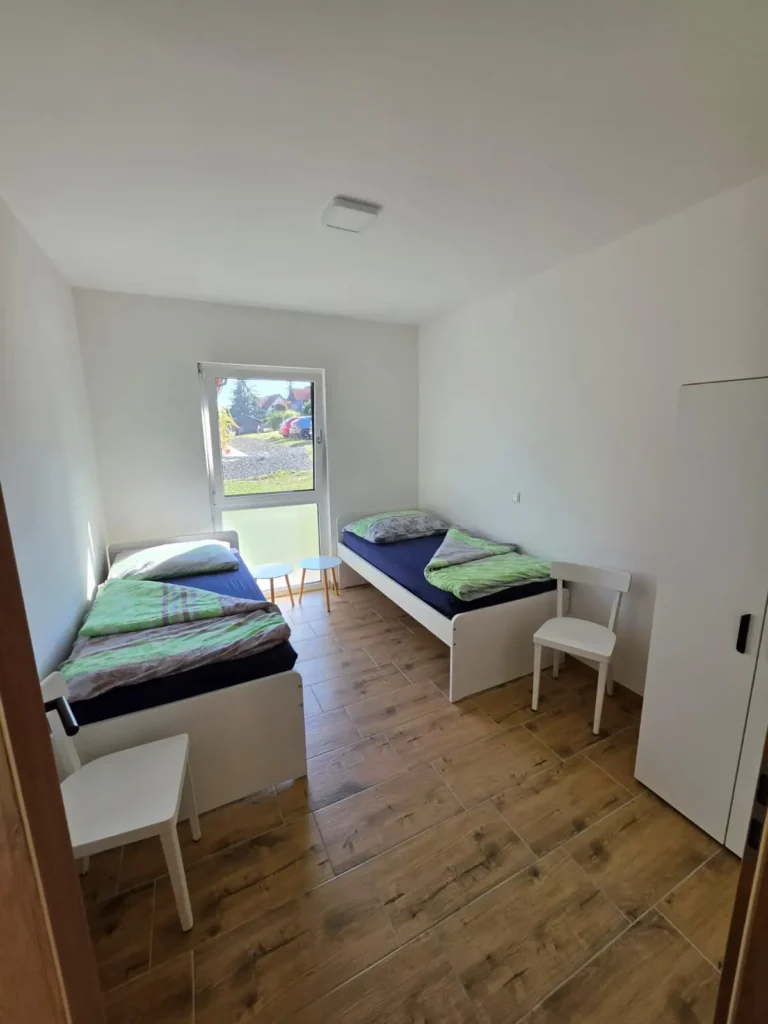 Kinderzimmer mit zwei getrennten Betten mit Blick aus dem Fenster