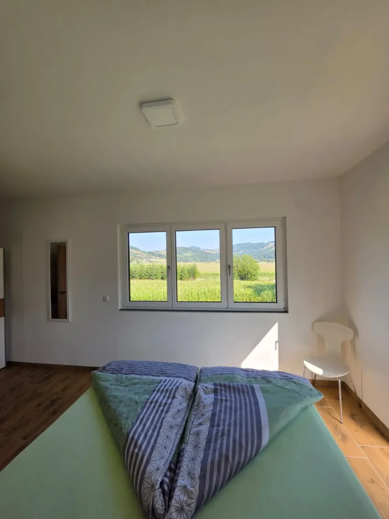 Schlafzimmer mit Doppelbett und großer Fensterfront