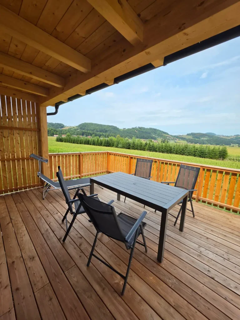 Balkon mit Holzboden Tisch und vier Stühlen